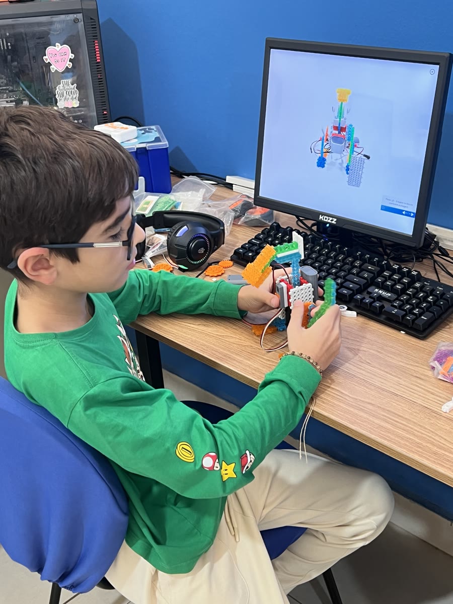 Criança montando um robô na aula